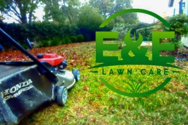  E&E Logo next to push mower in the fall